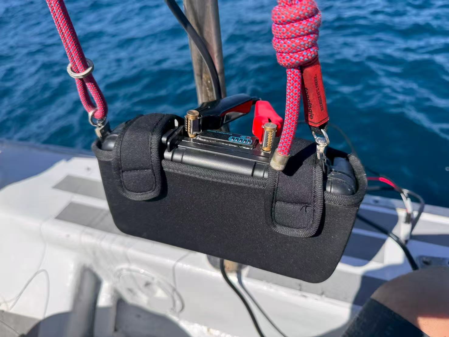Rugged portable battery photographed in a marine fishing environment to highlight protective design